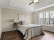 Bedroom with hardwood floors and neutral tones, featuring a tray ceiling and a view of the trees outside at 366 Greycoat Sw Blf, Marietta, GA 30064