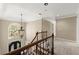 A stairway hallway with decorative railing, arched window, and chandelier illuminating the space at 3300 Greencastle Chase Ne, Marietta, GA 30062