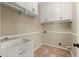 Neat laundry room featuring a sink, tiled floor, and convenient upper cabinets with storage at 3300 Greencastle Chase Ne, Marietta, GA 30062