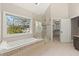 Well-lit main bathroom with a soaking tub, walk-in shower, and large window offering scenic views at 3300 Greencastle Chase Ne, Marietta, GA 30062