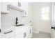 Laundry room with white cabinets, quartz countertops, and patterned flooring at 185 Marion # B, Atlanta, GA 30307