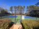 Two tennis courts with a fence and surrounding trees at 2002 Country Park Se Dr, Smyrna, GA 30080