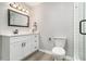 Bathroom featuring a vanity with white cabinets and drawers, modern light fixture and glass enclosed shower at 2002 Country Se Dr, Smyrna, GA 30080