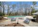 Community pool surrounded by trees with picnic tables and lounge chairs at 2002 Country Se Dr, Smyrna, GA 30080