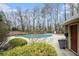 Community pool surrounded by trees with lounge area and bath house at 2002 Country Se Dr, Smyrna, GA 30080