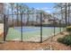 Community tennis court with green and blue surface surrounded by trees at 2002 Country Se Dr, Smyrna, GA 30080