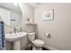 Small bathroom with white pedestal sink, toilet, and decorative artwork at 1184 Warner Park Ct, Decatur, GA 30033