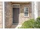 Dark brown front door with sidelights and brick facade at 2375 Morgan Farm Dr, Buford, GA 30519