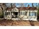 Tan house with brown roof, front porch, and mature trees in the yard at 2642 Joyce Ave, Decatur, GA 30032