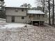 Back of house with deck and snowy yard; two-story home at 4906 Holbrook Cir, Duluth, GA 30096