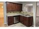 Corner kitchen with dark wood cabinets and stainless steel dishwasher at 5863 Seabright Ln, Atlanta, GA 30349