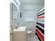Clean bathroom with white vanity, tiled floors, and a striped shower curtain at 692 Argonne Ne Ave # 2, Atlanta, GA 30308
