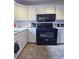 Kitchen with white cabinets, black appliances, and tile flooring at 692 Argonne Ne Ave # 2, Atlanta, GA 30308