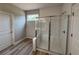Modern bathroom with a large glass-enclosed shower and wood-look tile floors at 14 Cambridge Ln, Dallas, GA 30157