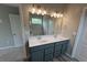 Bathroom featuring a double vanity, large mirror, and modern lighting fixtures at 14 Cambridge Ln, Dallas, GA 30157