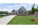 Inviting single-Gathering home with stone accents, teal siding, a well-manicured lawn, and long driveway at 14 Cambridge Ln, Dallas, GA 30157