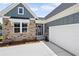 Charming home featuring a stone facade, teal siding, a well-manicured lawn, and a two-car garage at 14 Cambridge Ln, Dallas, GA 30157