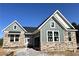 Charming single-Gathering home featuring stone accents, green siding, and a welcoming front entrance at 14 Cambridge Ln, Dallas, GA 30157