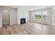 Bright, open-concept living room boasts stylish fireplace, hardwood floors, and a view of balcony and outdoor scenery at 14 Cambridge Ln, Dallas, GA 30157