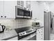 Modern kitchen with stainless steel appliances and tile backsplash at 4100 Paces Se Walk # 2304, Atlanta, GA 30339