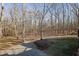 Wooded backyard with a gravel driveway at 1422 Hillside Dr, Grayson, GA 30017