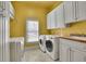 Bright laundry room with washer, dryer, and cabinets at 1422 Hillside Dr, Grayson, GA 30017