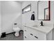 Modern half bath with a white vanity, marble countertop, black hardware, and window for natural light at 1822 Avon Sw Ave, Atlanta, GA 30311