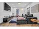 Living room with sectional sofa, hardwood floors, and a large TV at 1822 Avon Sw Ave, Atlanta, GA 30311