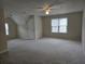 Spacious bedroom with neutral carpeting, a ceiling fan, and natural light from multiple windows at 4019 Kingsbrook Blvd, Decatur, GA 30034