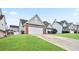 Tan brick house with white garage door and a lush green lawn at 559 Ransom Way, Stockbridge, GA 30281