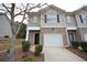 Two-story townhome with brick and siding exterior, attached garage, and landscaping at 3284 Pennington Dr, Lithonia, GA 30038