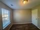 Neutral bedroom features a window providing natural light and wood-look flooring at 7645 Broadhurst Dr, Riverdale, GA 30296