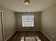 Neutral bedroom features a window providing natural light and wood-look flooring at 7645 Broadhurst Dr, Riverdale, GA 30296