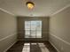 Dining Room features chair rail detail, a window providing natural light and wood-look flooring at 7645 Broadhurst Dr, Riverdale, GA 30296