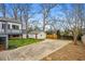 Large backyard with a detached garage, mature trees, a wooden fence, and a two-story home at 3215 Concord Cir, Smyrna, GA 30080