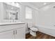 Bright bathroom features modern white cabinets, sleek countertop, and tub with tiled walls at 3215 Concord Cir, Smyrna, GA 30080