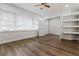 Bedroom featuring wood-look floors, white walls and trim, large windows, ceiling fan and built-in shelving at 3215 Concord Cir, Smyrna, GA 30080