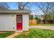 Exterior of garage with red door and window, white siding, a pathway, and green grass at 3215 Concord Cir, Smyrna, GA 30080