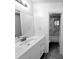 Modern bathroom featuring a vanity with storage, a large mirror, sleek fixtures, and an adjacent tiled shower over tub at 3278 Abbeywood Dr, Decatur, GA 30034
