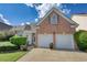 Brick house with a two-car garage and well-maintained landscaping at 1305 Leisure Lake Dr, Lawrenceville, GA 30044
