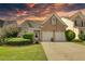 Brick home with two-car garage and landscaped yard at sunset at 1305 Leisure Lake Dr, Lawrenceville, GA 30044