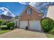 Two-car garage with brick exterior and landscaping at 1305 Leisure Lake Dr, Lawrenceville, GA 30044