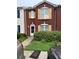 Brick townhouse with a landscaped yard and two-car driveway at 2087 Grove Way, Hampton, GA 30228