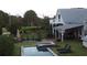 Expansive backyard with a pool, spa, garden, and a charming white farmhouse in the background at 10975 Hutcheson Ferry Rd, Chattahoochee Hills, GA 30268