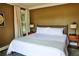 Bedroom with hardwood floors, large bed with white linens, with mid-century modern end tables at 10975 Hutcheson Ferry Rd, Chattahoochee Hills, GA 30268