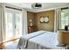 Bedroom with hardwood floors, modern ceiling fan, and a large bed with white linens and french doors at 10975 Hutcheson Ferry Rd, Chattahoochee Hills, GA 30268