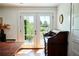 Bright dining space with hardwood floors, double french doors leading to the garden, and a vintage secretary at 10975 Hutcheson Ferry Rd, Chattahoochee Hills, GA 30268