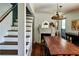 Cozy dining room featuring hardwood floors, fireplace, large wood table, and decorative lighting fixture at 10975 Hutcheson Ferry Rd, Chattahoochee Hills, GA 30268