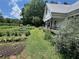 Beautiful farmhouse with a lush garden, charming front porch, and a tranquil rural setting at 10975 Hutcheson Ferry Rd, Chattahoochee Hills, GA 30268
