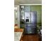 Kitchen featuring stainless steel refrigerator and green cabinets, complemented by a view of the island at 10975 Hutcheson Ferry Rd, Chattahoochee Hills, GA 30268